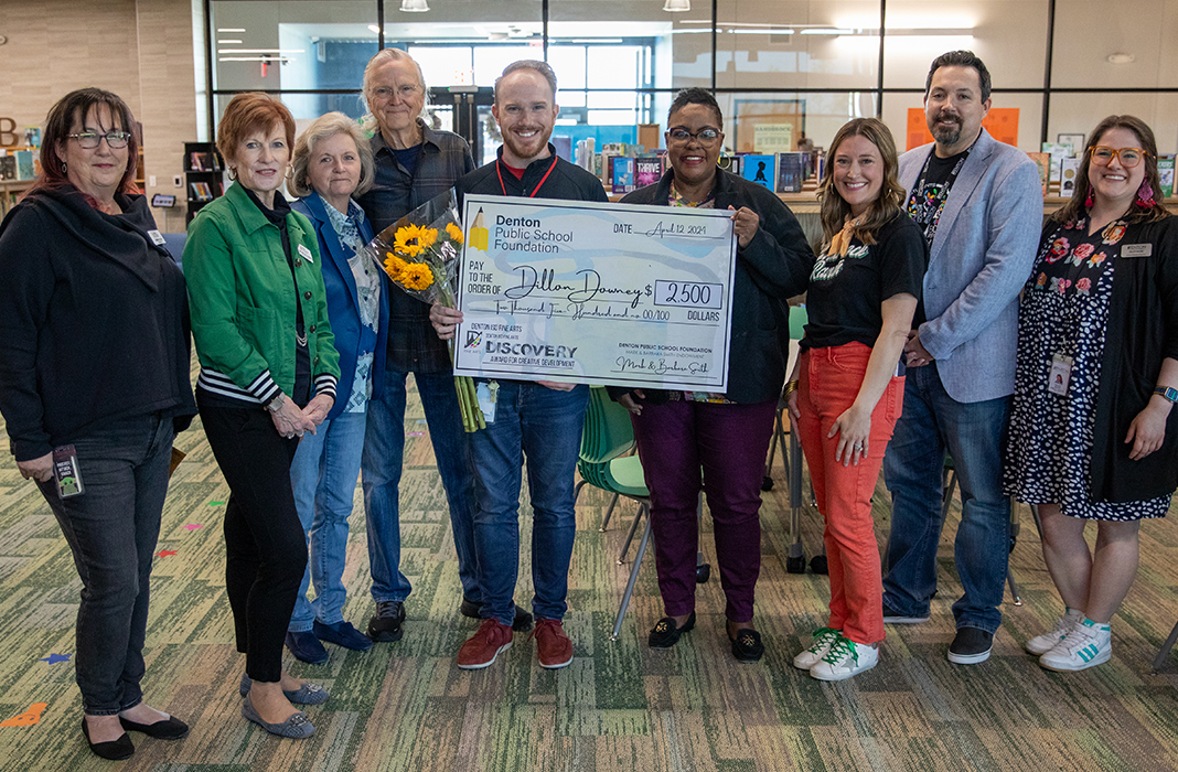 Dillon Downey holding a check with Staff 